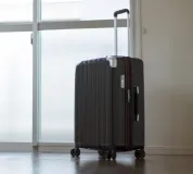 スーツケースと空港の風景。新しい勤務地へ赴任するイメージ。
