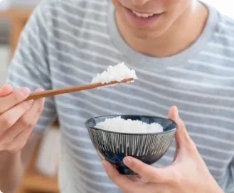 食事支援で提供されるご飯やラーメンを食べる男性のイメージ